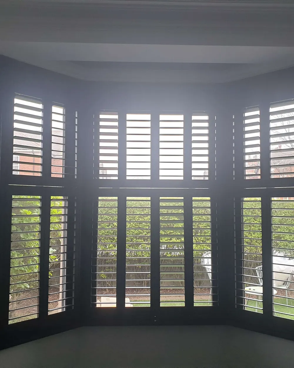 Bay window fitted with grey tier-on-tier Boston shutters