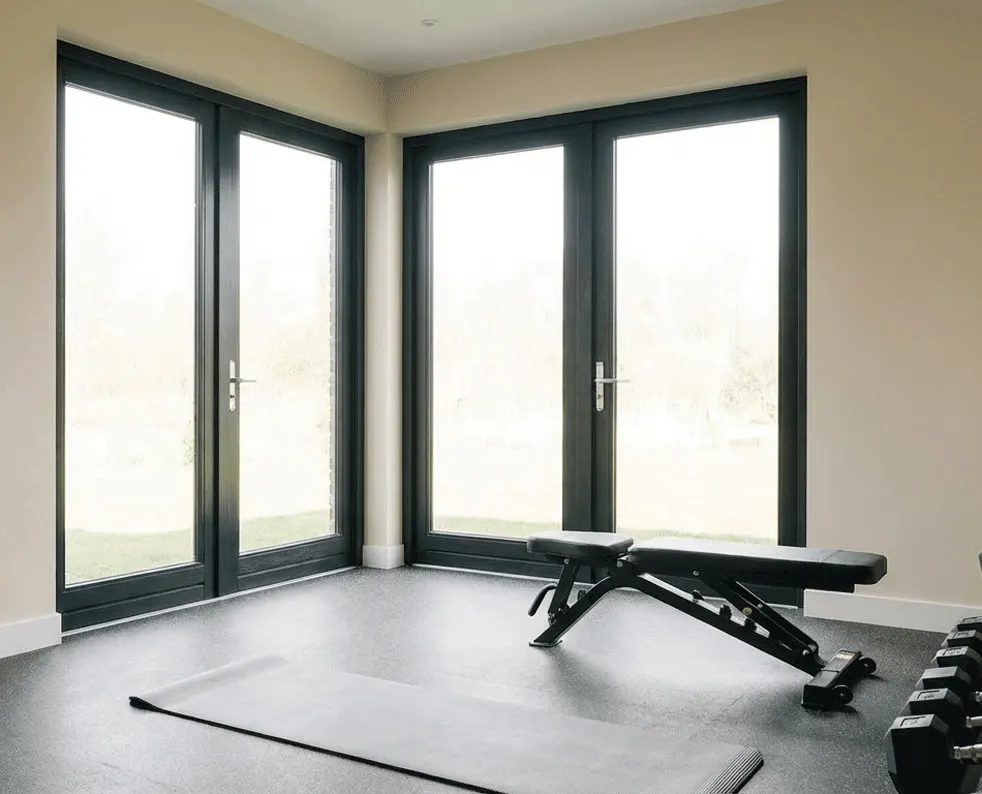 Corner doors in a home gym with no shutters yet