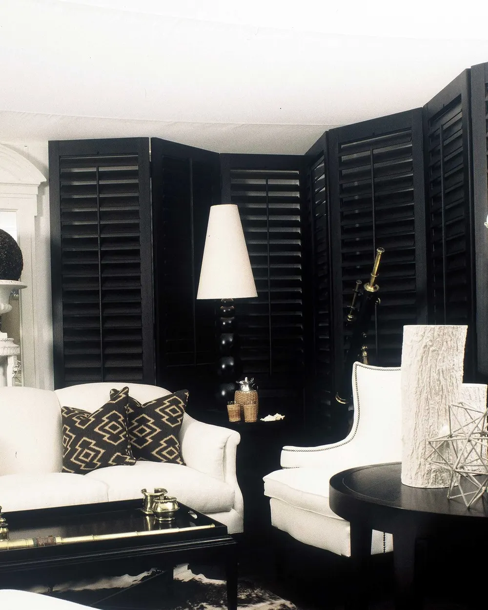 White living room with tall windows dressed in black Georgia shutters