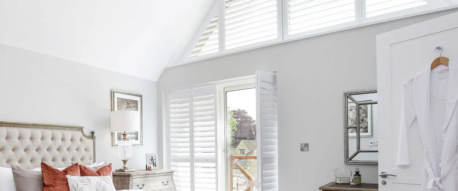Gable bedroom window with shutter panels shaped to its angled top