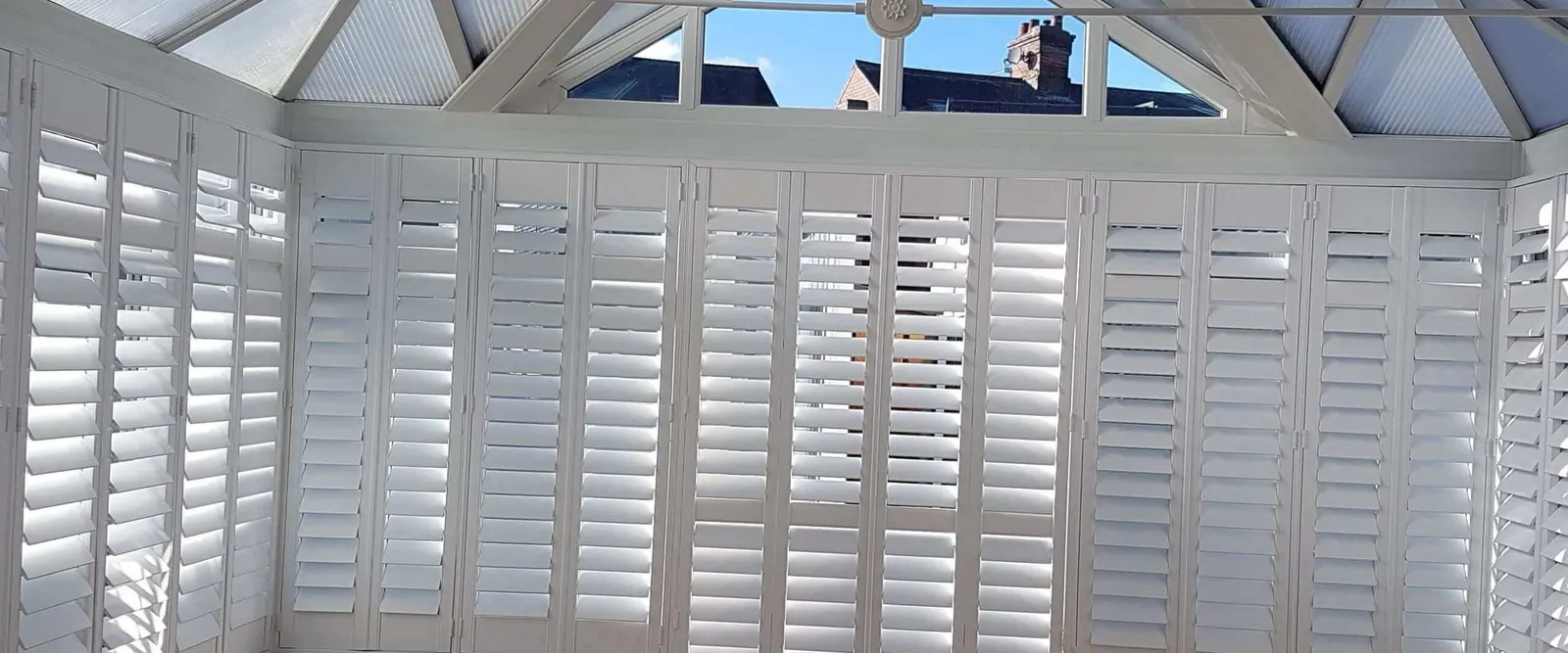 Conservatory with white shutters on every window