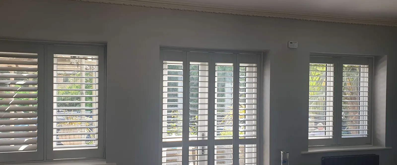 Grey living room with two tall windows fitted with Georgia shutters