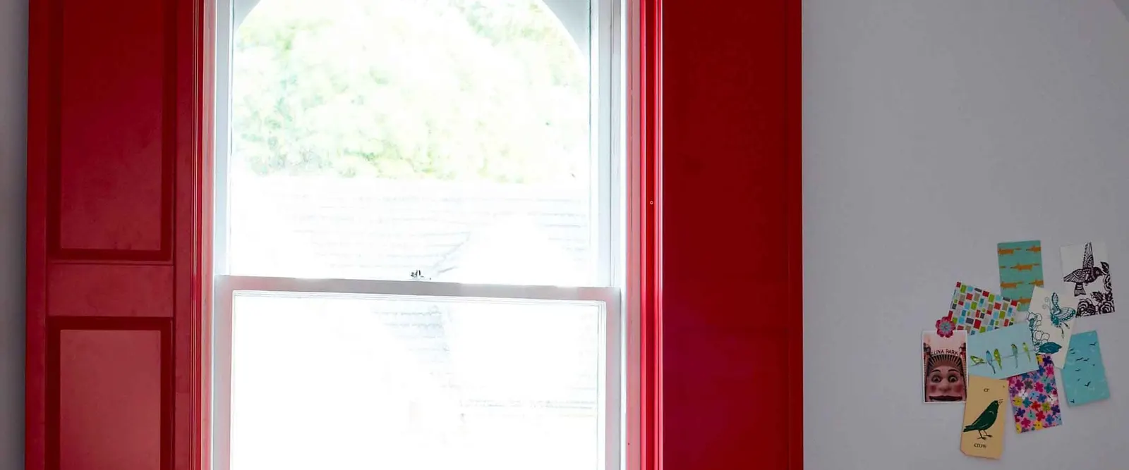 Bedroom window with red solid panel shutters
