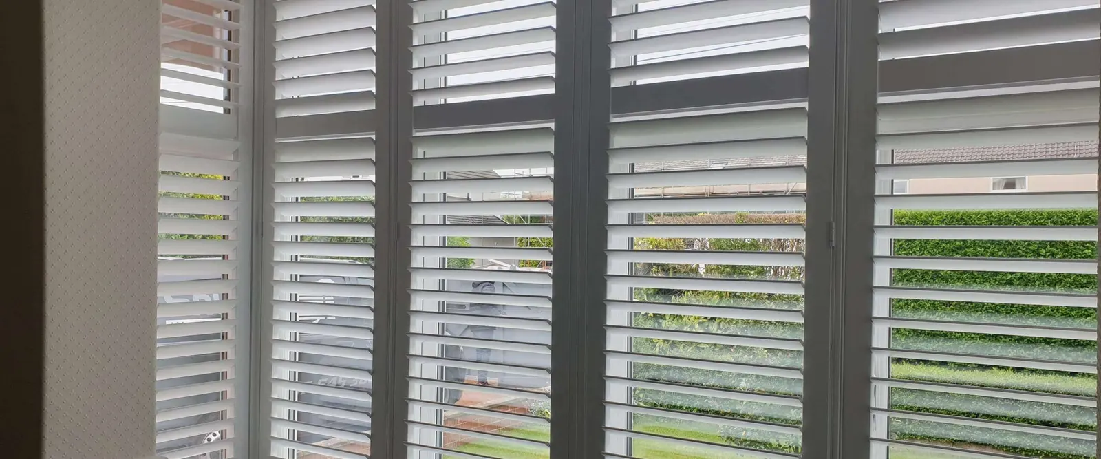Square bay window with white shutters on all three faces