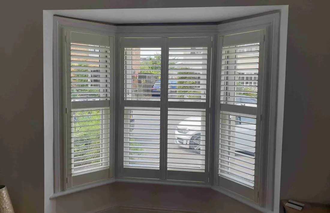 Angled bay window with white shutters on every face