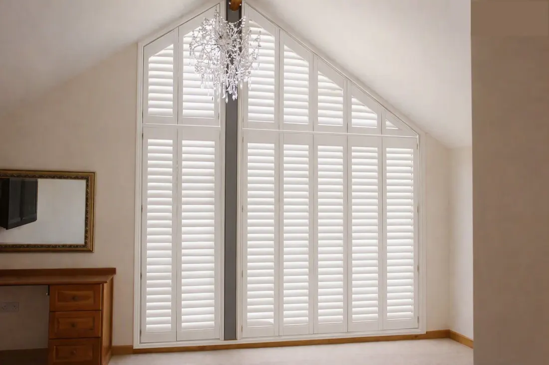 Finished angled white shutters in a tall gable window