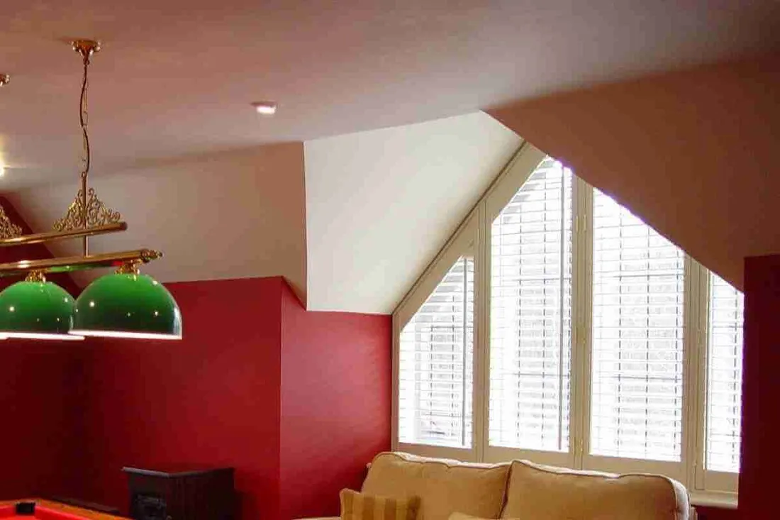 Red games room with white shutters on an angled window