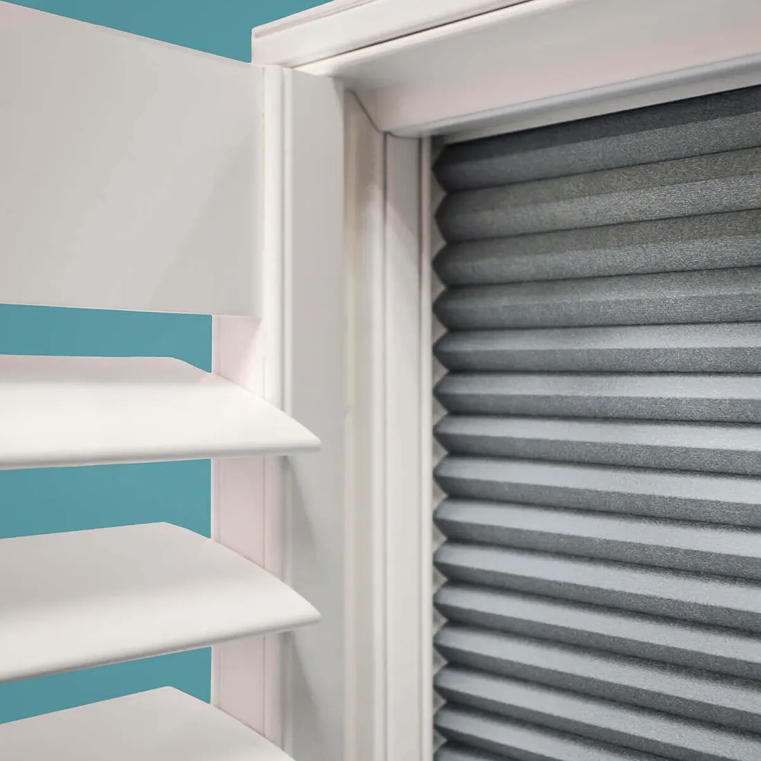 White shutter panel swung open to show the blackout blind pulled down behind it