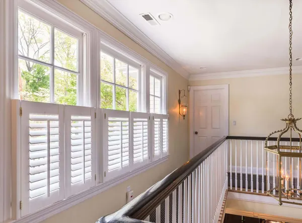 Landing windows over a staircase, each fitted with white café style shutters