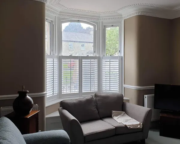 Grey sofa in a lounge bay dressed with white café style shutters