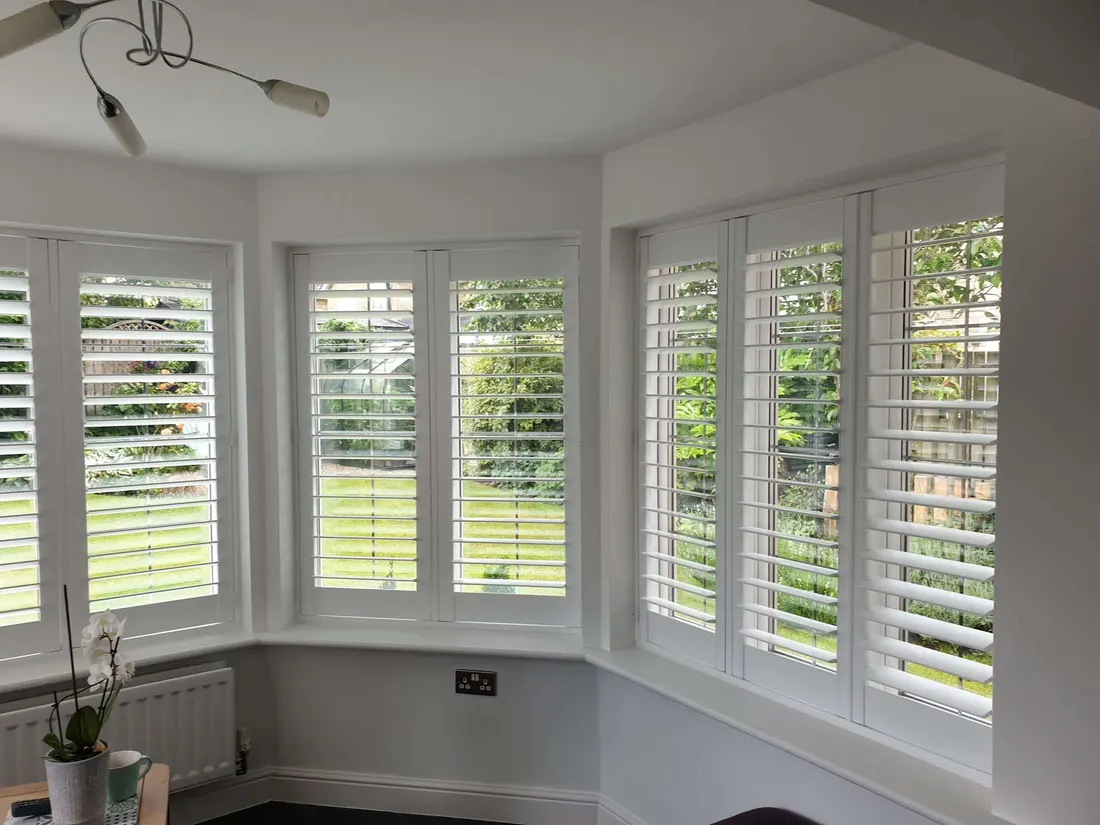 Conservatory corner fitted with white shutters