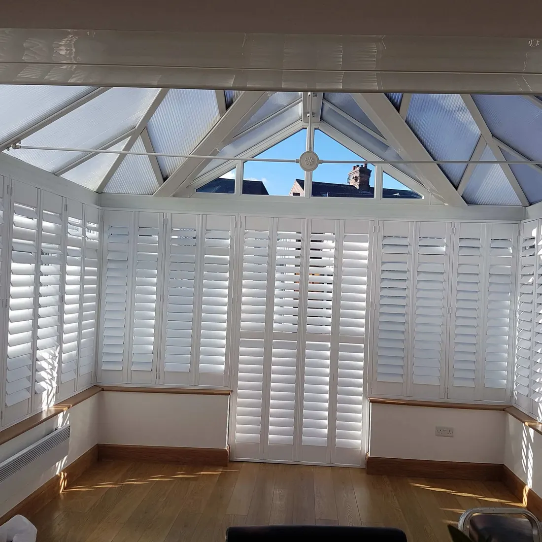 Conservatory with white shutters on its walls and doors