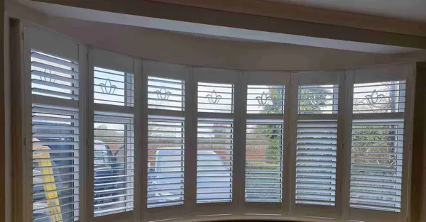 Wide curved bay with a white shutter on each window