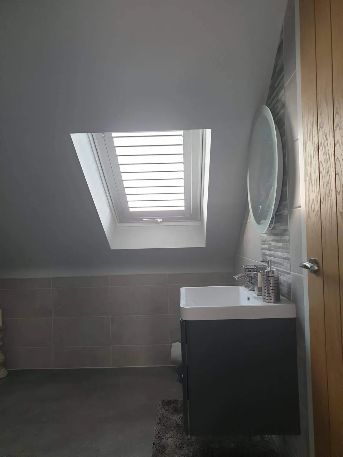 Bathroom sloping ceiling with a skylight shutter set into it