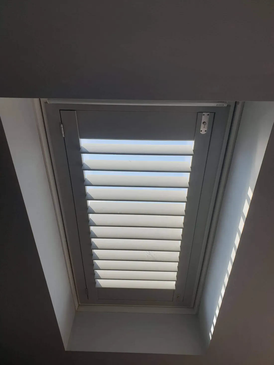 Steep sloped ceiling with a long skylight shutter