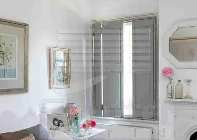Sitting room window with grey solid panel shutters part closed