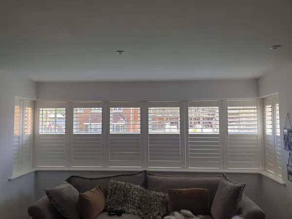 Lounge sofa under a long square bay of tier-on-tier shutters