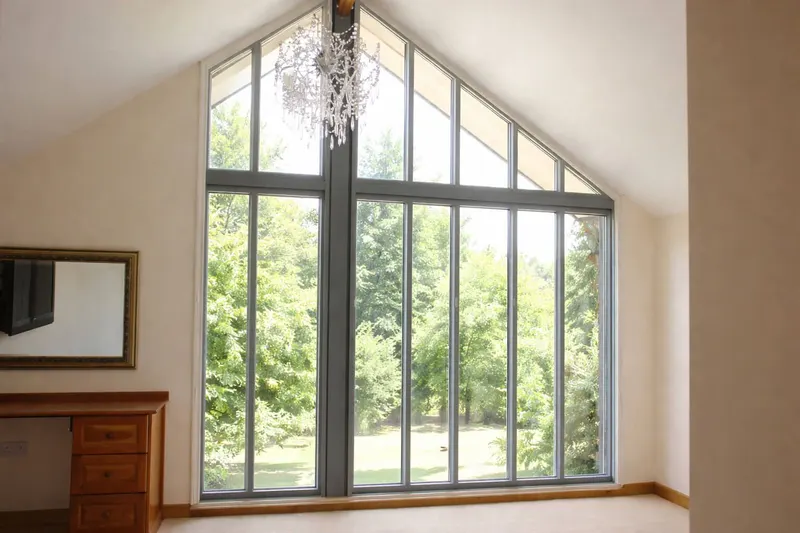 Bedroom with a tall gable window following the slope of the roof